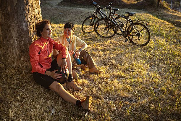 Aerial view of woman riding mountain bike on flowering grassland mountain trail