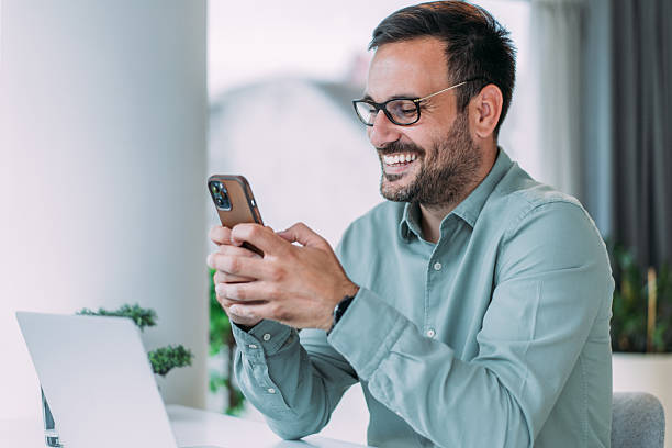 istock Businessman using laptop and texting on cellphone in the office. 2229356701