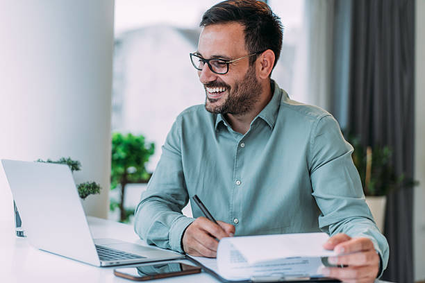 istock Successful businessman in modern office working on laptop and signing a contract. 2229356708