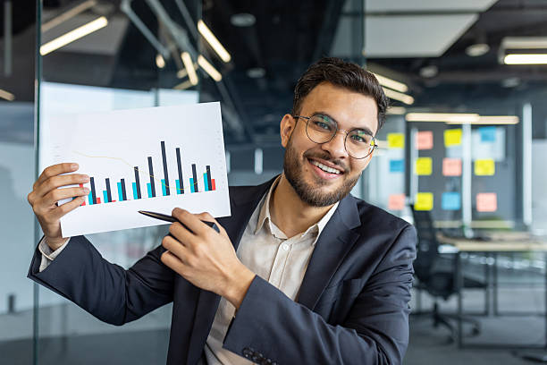 istock A professional man presenting a business chart with a smile in an office setting. 2229357076