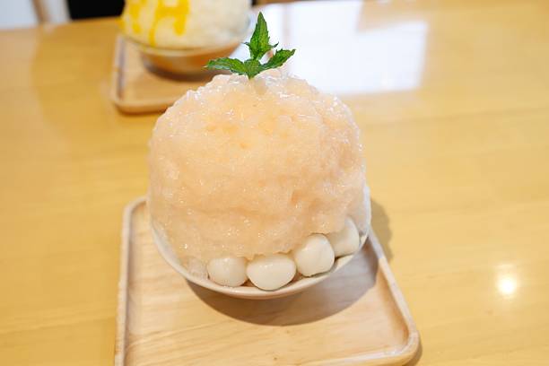 istock shaved ice topped with peach syrup. 2229360056