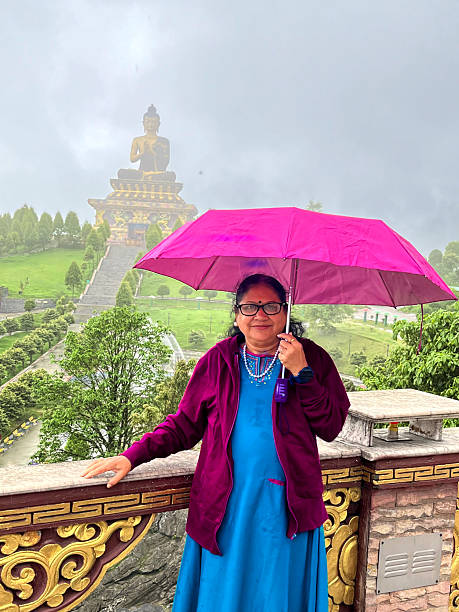 istock Rainy day beautiful lady traveler is posing at Chenrezig statue in Pelling 2229361687
