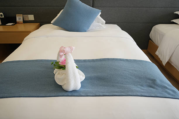 Hotel bed making with towel folded flowers decoration