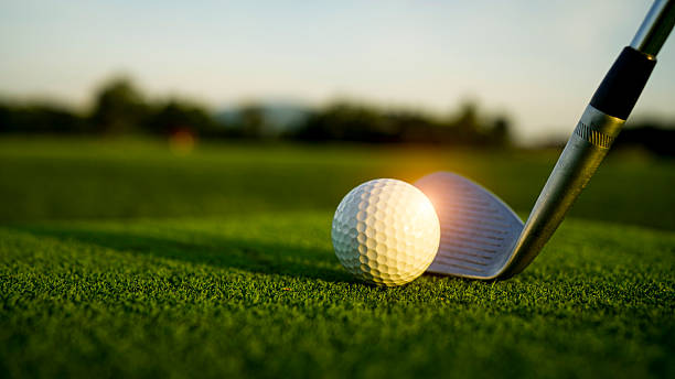 istock Golf ball on green grass in the evening golf course with sunshine background. 2229362949