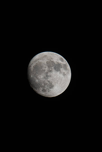 Full moon illuminates earths cratered satellite a gray orb against the inky void.