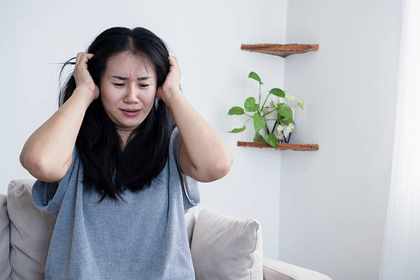 istock Stressed Asian woman with headache massaging temples 2229371139