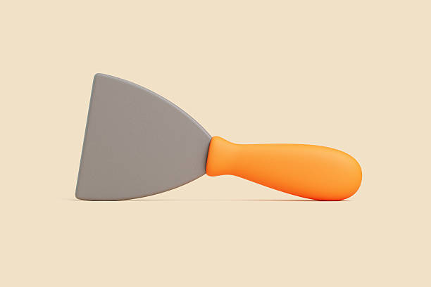 istock Putty Knife with Orange Handle Lying Flat on Beige Background 2229372514
