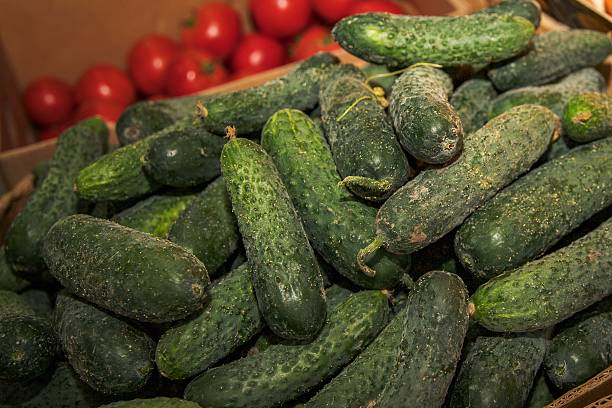 istock Fresh cucumbers, tomatoes and citrus at market 2229376130