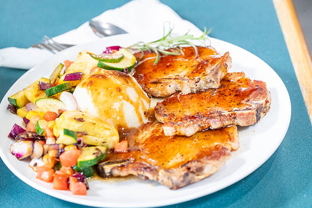 bourbon pork chops. mashed potatoes and grilled veggies in a restaurant setting