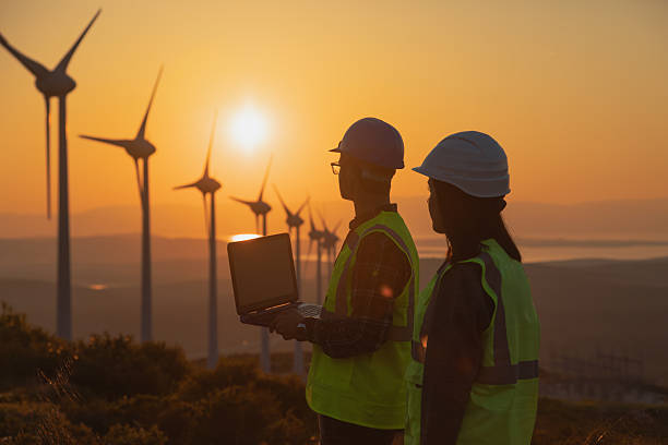 istock Male and Female Engineers Using AI Technology for Wind Turbine Inspection at Sunset 2229378351