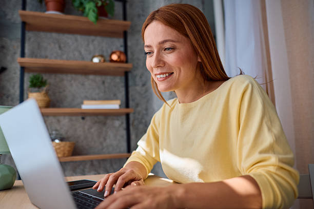 istock Woman working from home typing on laptop and smiling 2229380333