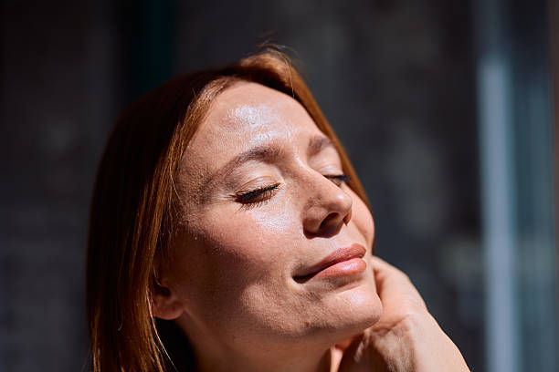 istock Serene woman enjoying sunlight with closed eyes and peaceful expression 2229380401