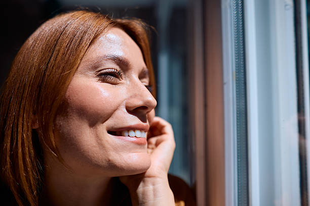 istock Serene woman smiling and looking out the window 2229380424