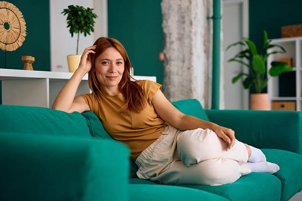 istock Serene woman relaxing on comfortable sofa at home, enjoying peaceful moment 2229380512