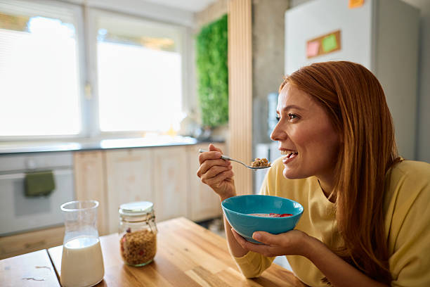 istock Young woman enjoying a healthy breakfast in her kitchen 2229380659