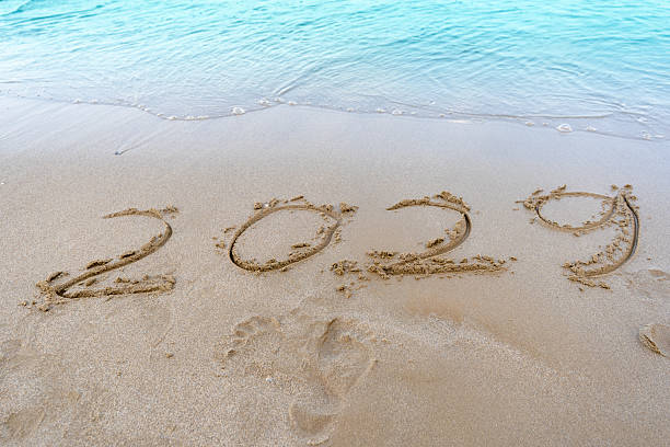 istock 2029 numbers written in the sand. Sea wave beach 2229381877