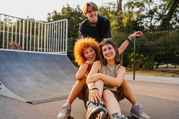 Three young friends playing in a skateboard park