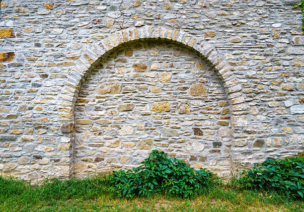 old stone wall with arch create a frame with blank space, close up of beautiful and cozy architectural details