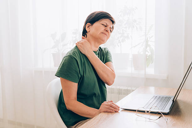 istock Elderly caucasian female experiencing neck pain while using laptop at home 2229396384