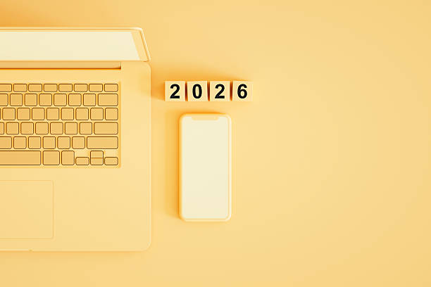 istock 2026 New Year, Blank Screen Smartphone and Laptop on Yellow Background 2229396796