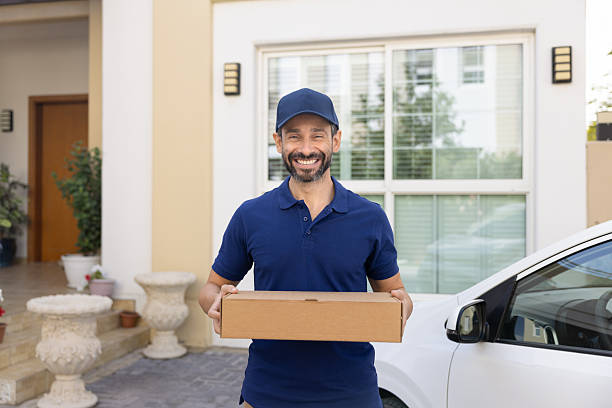 istock Portrait of deliveryman posing outdoors with cardboard parcel box 2229398306