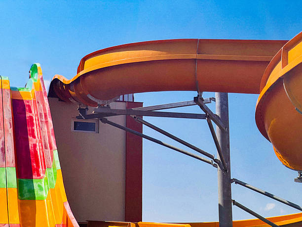 A vibrant and colorful water slide structure is displayed against a bright blue sky, showcasing a fun and exciting summer scene.