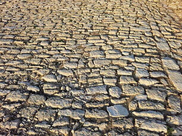 A close-up of a stone wall. Ground. Outdoor. Brick. Rock. Way