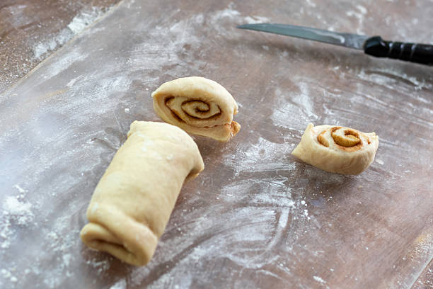 istock Dough, rolled into roll, is cut into slices for baking cinnamon buns 2229400519