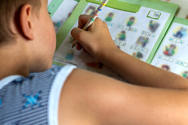 istock Child is doing his English homework, writing diligently in his notebook. Homeschooling on hot summer day 2229400557