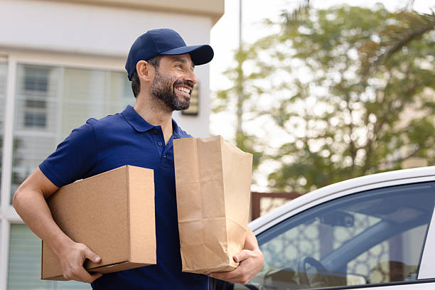 istock Courier carrying parcel and bags with ordered goods to client 2229403638