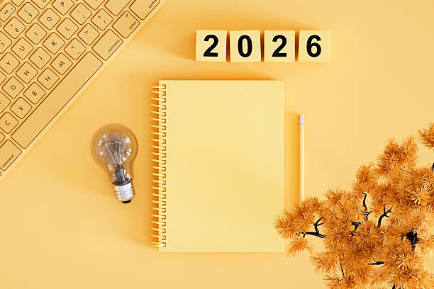 istock 2026 New Year, Lightbulb and Blank Page Notebook on Yellow Background, New Idea Concept 2229404998