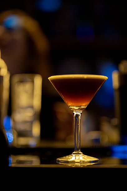 istock Sleek espresso martini garnished with coffee beans, resting on dark wooden bar surface with soft ambient lighting blurring background 2229405335