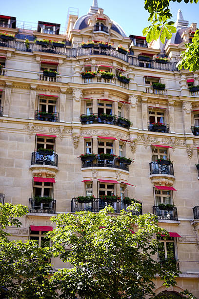 istock Classic Parisian building with balconies and green trees in summer 2229408671