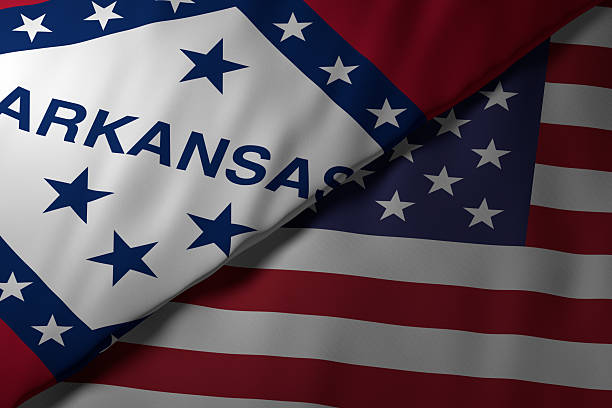 Close-up view of the Arkansas state flag alongside the United States national flag. The vibrant colors and fabric texture highlight the unity and identity of the state within the nation.