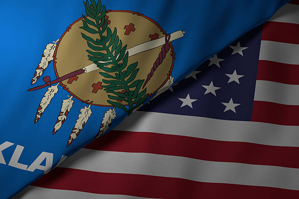 Close-up view of the Oklahoma state flag alongside the United States national flag. The vibrant colors and fabric texture highlight the unity and identity of the state within the nation.