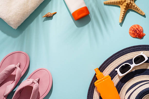 istock Sunscreen, sunglasses and seashell on blue background with hard sunny shadows. 2229413032