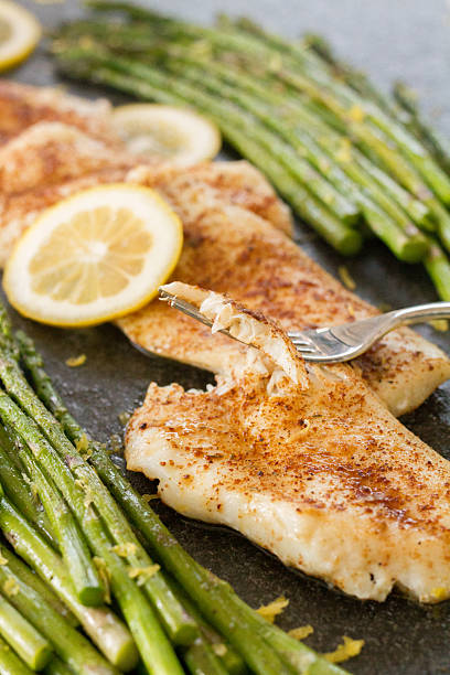 istock Seasoned, baked, orange roughy with asparagus 2229413212