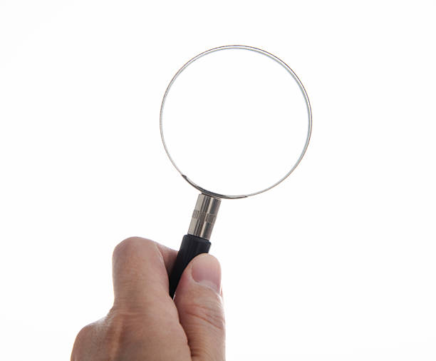 Hand holding the magnifying glass isolated on white background