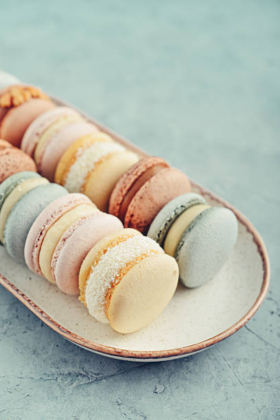 Colorful french macarons on plate on blue background