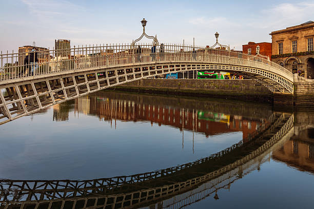 Dublin, Ireland - June 10 2025 : 19th century Ha'penny Bridge across the River Liffey, Wellington Quay, Dublin.