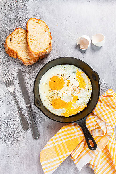 Freshly cooked eggs in a pan, served with bread, on the kitchen counter,breakfast, natural light, no people,