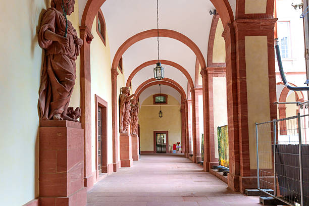 Darmstadt, Germany - June 5, 2025: Architectural details of an arcaded corridor featuring classic statues, warm lighting, and historical elements in Darmstadt, Germany.
