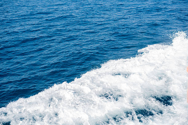 Water trail foaming behind a ferry boat in Atlantic ocean between Canary islands, Spain. Fuerteventura island on the background
