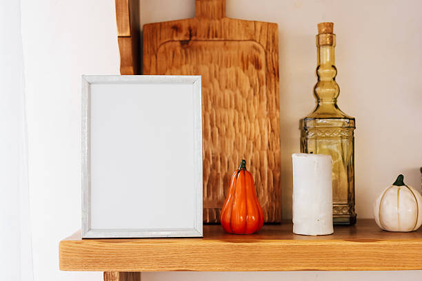 istock Decorative kitchen shelf display featuring pumpkins and empty frame for seasonal decor 2229431287