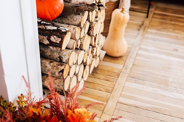 istock Autumn decor with firewood and pumpkins in a cozy indoor setting 2229431549