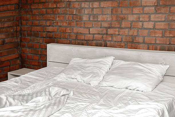 istock Comfortable rumpled messy crumpled bed white cotton sheets,duvet,blanket and pillows in morning after sleep,bedroom interior 2229435718
