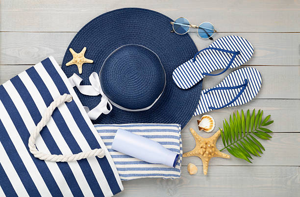 istock Blue beach bag with summer accessories on wooden background, top view 2229435788