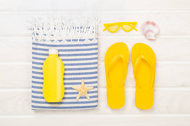istock Beach towel with summer accessories on wooden background, top view 2229435792