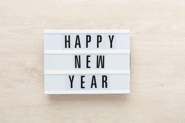 Lightbox with Happy New Year on wooden background, top view