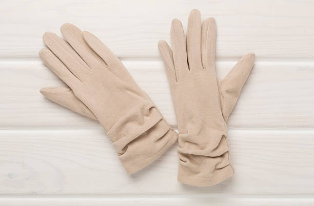 istock Beige gloves on wooden background, top view 2229437428